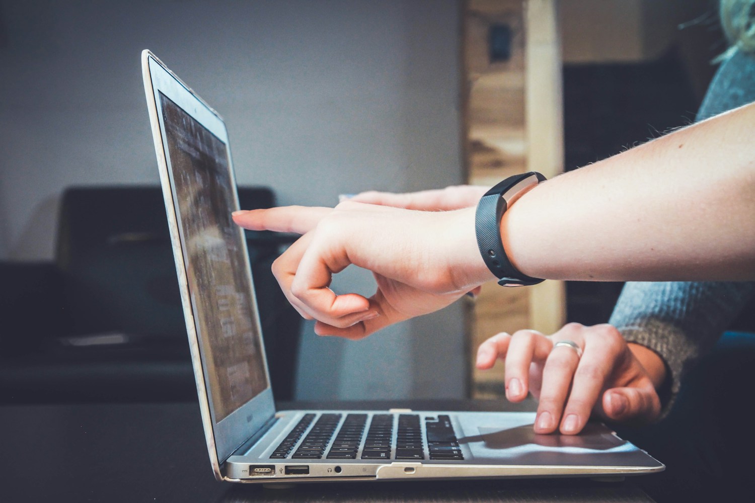 People sharing ideas around a laptop
